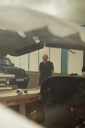 Pilot v hangáru u letadla