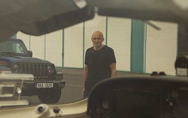 Pilot v hangáru u letadla